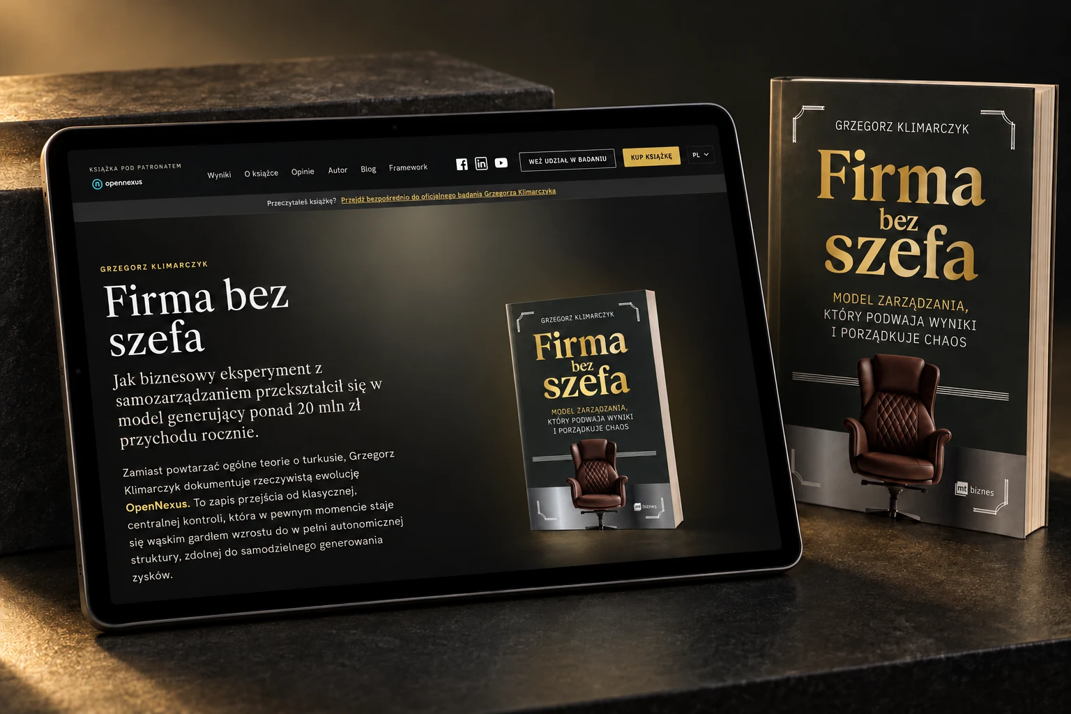 Strona Firma bez szefa na tablecie obok książki, w ciemnej aranżacji ze złotym światłem
