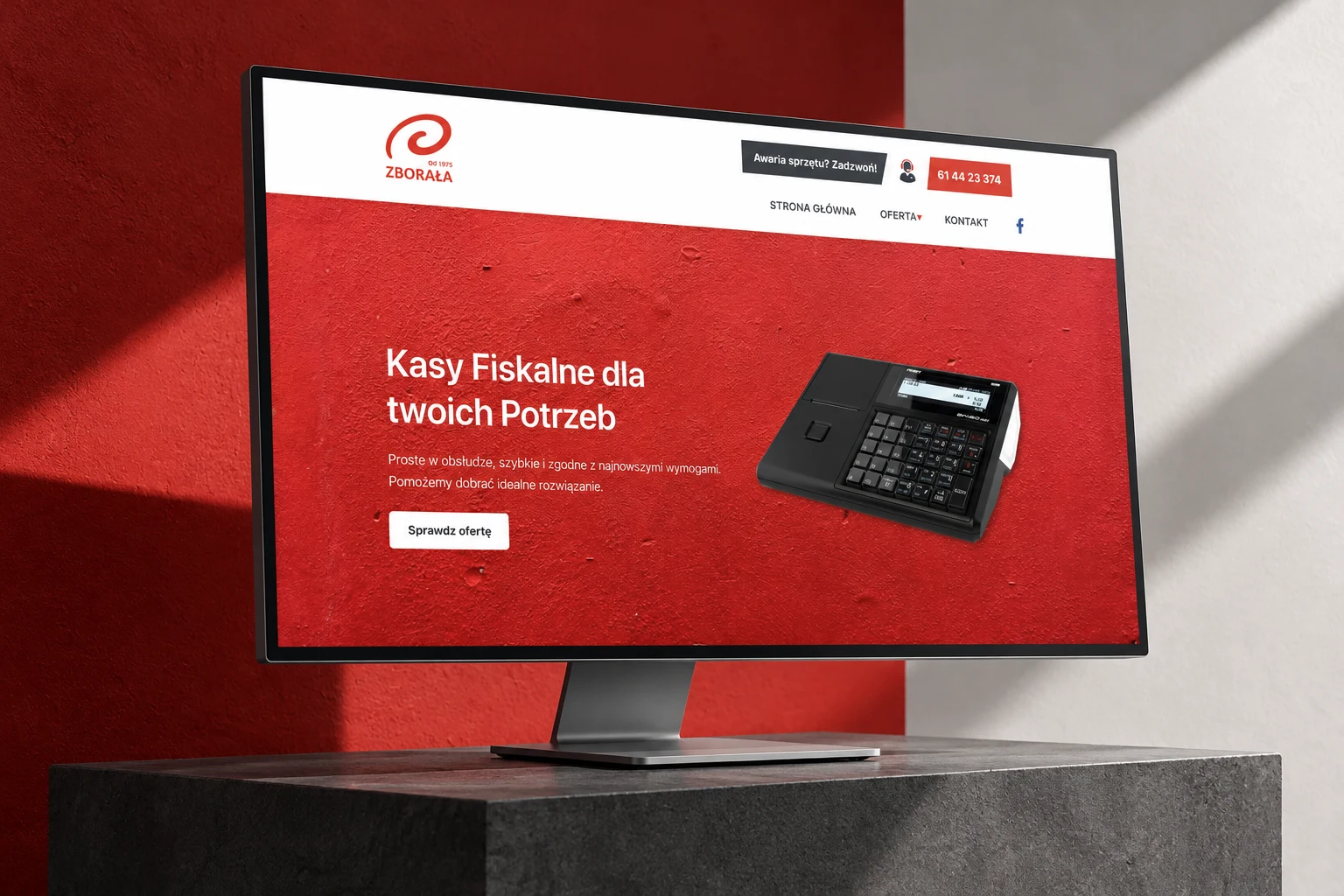 Strona kas fiskalnych Firmy Zborała na monitorze w czerwono-grafitowej aranżacji